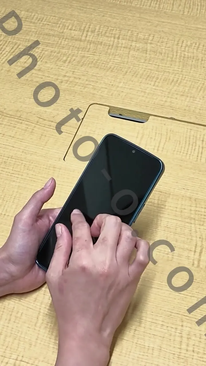 Close-up of hands holding and touching a smartphone with a dark display in the production preview; Photo-o.com watermark retained