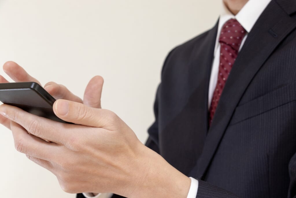 Man dressed in a suit holding a cellphone